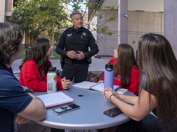 UAPD Police Officer speaking with UA students
